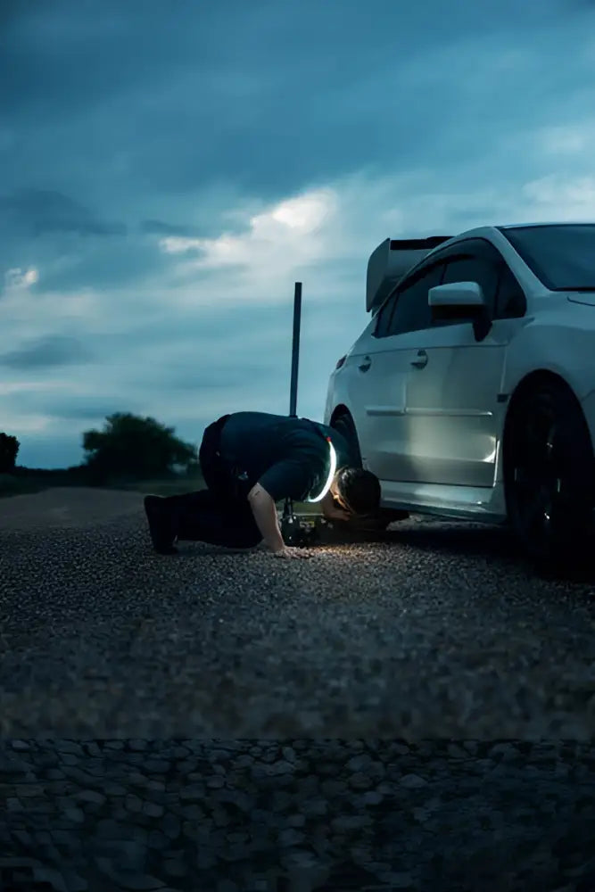 Valkoinen subaru wrx sti hatchback mustilla vanteilla ja takaspoilerilla sekä bando 1k strap light työvalo takakulmasta kuvattuna