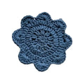 A hand-crocheted lasinalunen coaster in deep blue with a scalloped edge and textured pattern