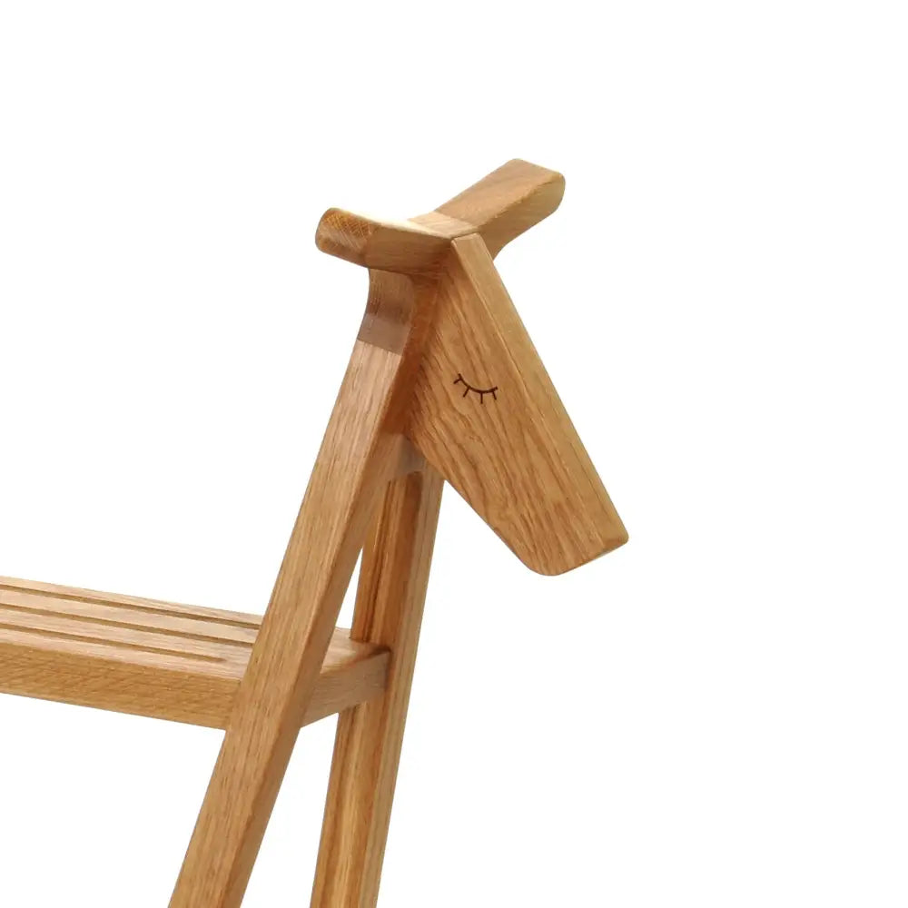 Vaaleasta puusta valmistettu minimalistinen lillagunga reindeer hylly, jossa on suljetut silmät