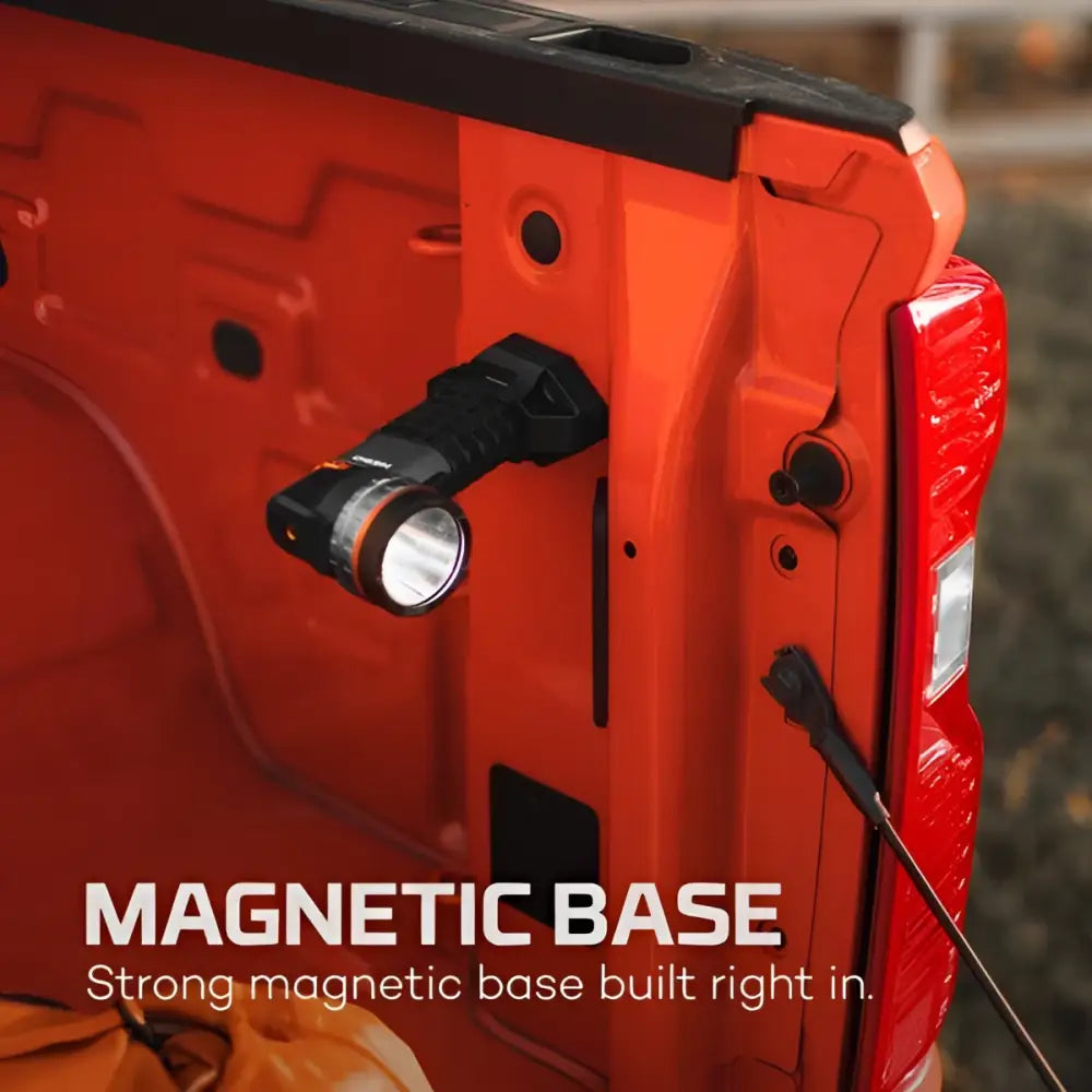Black and orange luxtreme sl 50 tactical flashlight with magnetic base mounted on side of orange truck bed