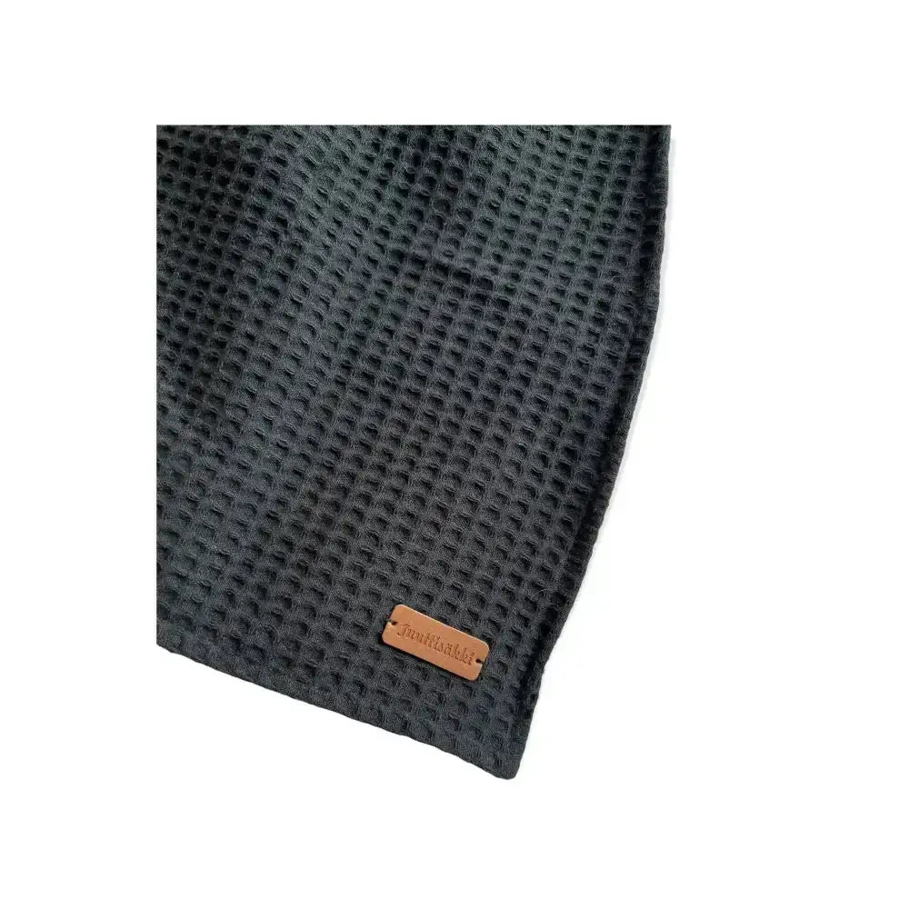 Dark gray waffle-weave näppipyyhe towel with brown leather tag made of absorbent cotton for kitchen use