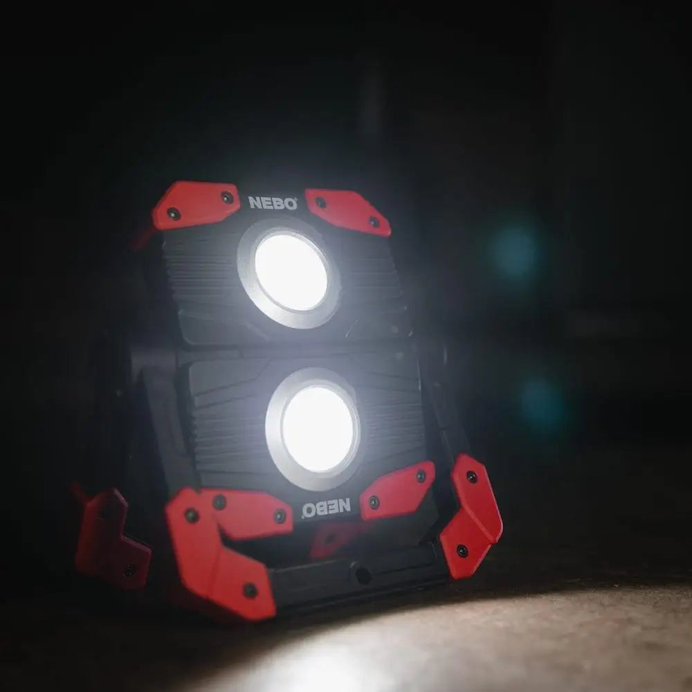 Red and black nebo omni 2k portable led work light with two bright circular bulbs for construction tasks
