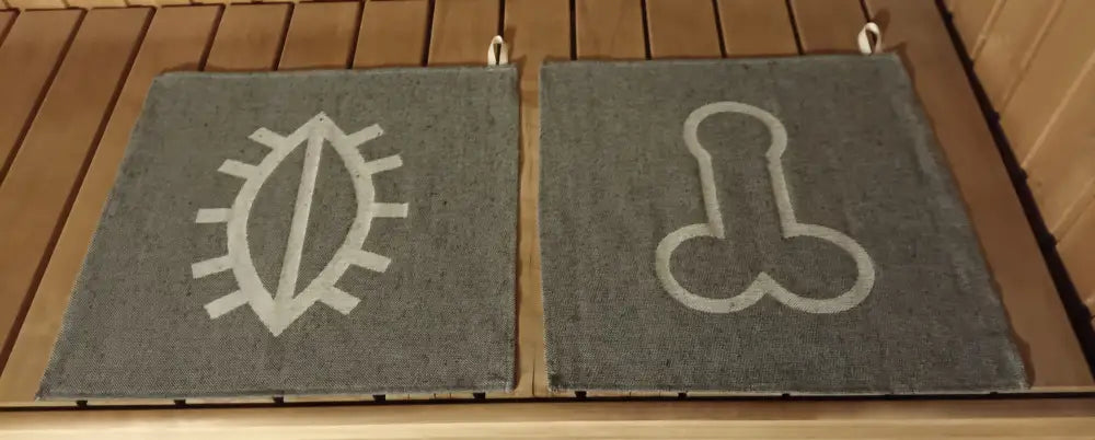 Harmaat teksturoidut pefletti pillunpäre -saunamatot valkoisilla kirjotuilla symboleilla