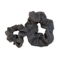 Musta pellava scrunchie kiiltävällä satiinipinnalla ja rypytetyllä tekstuurilla pellava scrunchiet -tuotteessa