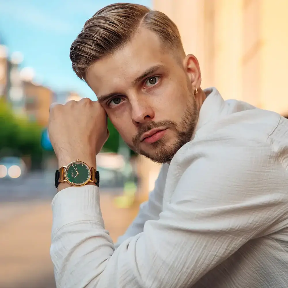 Kultainen revontuli eebenpuu 40mm kello vihreällä kellotaululla ja mustalla nahkarannekkeella miehen ranteessa