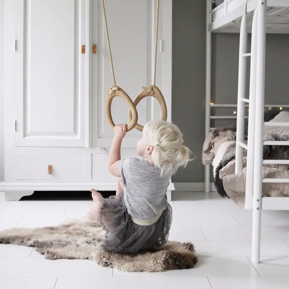 Light wood gymnastic rings oak beige suspended by rope for fitness training