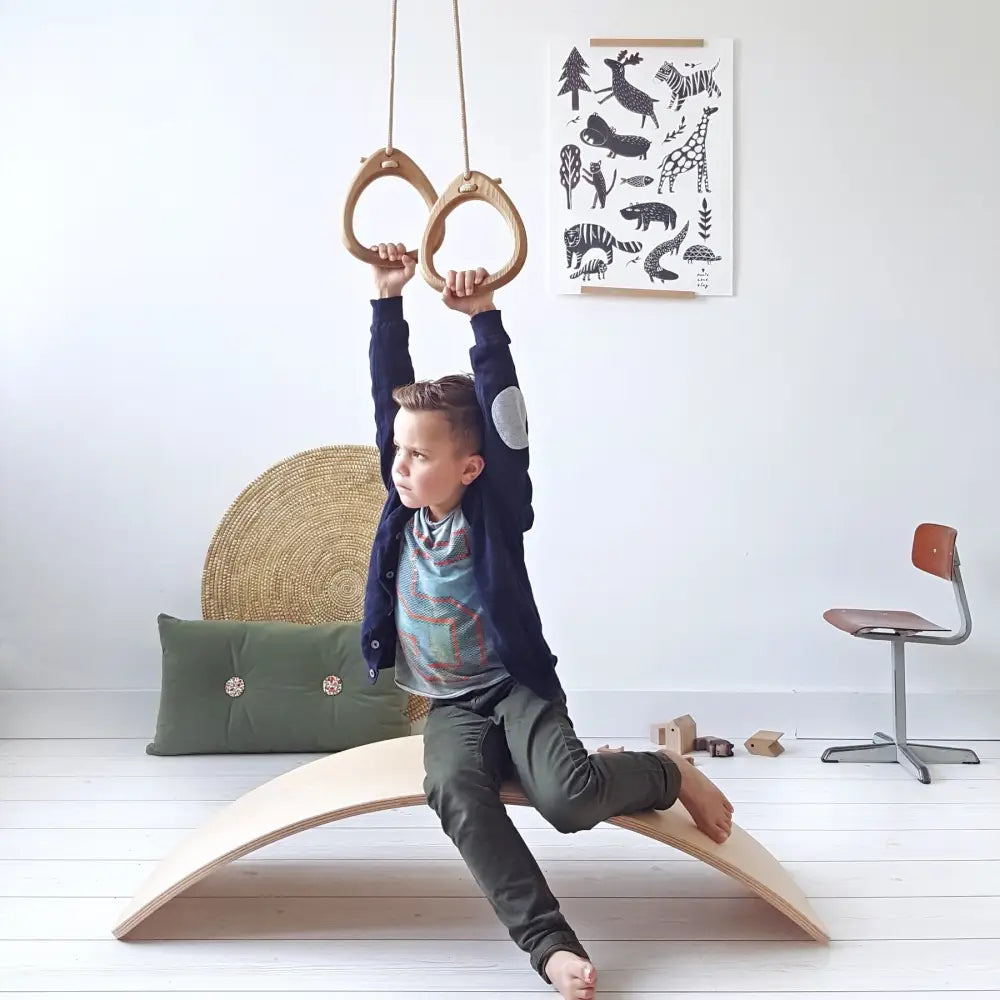 Light-colored oak balance beam rings with smooth curved surface and natural wood grain finish in white
