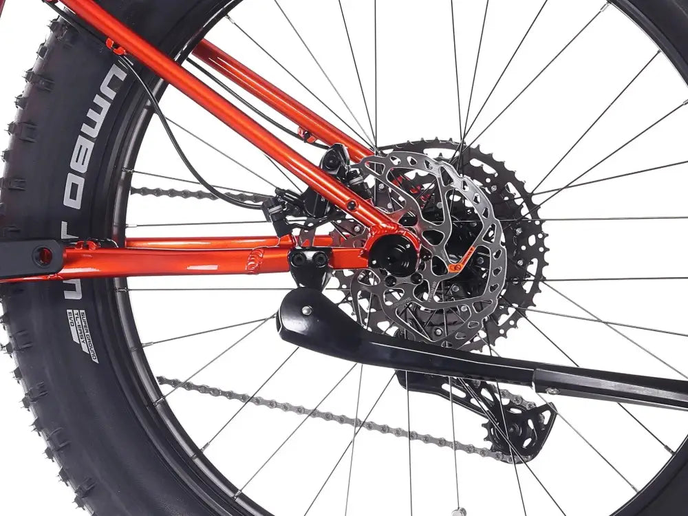 Orange rock machine vyöry e90 sähköpyörän runko mustilla komponenteilla ja levyjarrujärjestelmällä takapuolelta