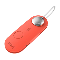 A sleek coral-colored knog smart luggage alarm with a silver button and metallic keychain loop in scout travel red