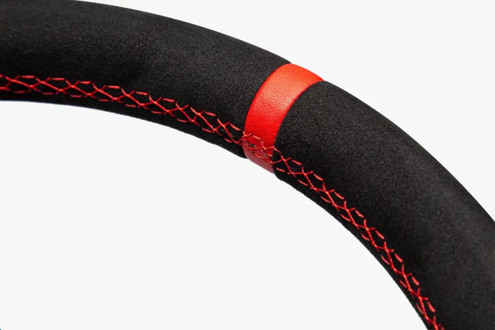 Simagic gt1 rounded steering wheel with black suede cover featuring red stitching and a red leather accent band