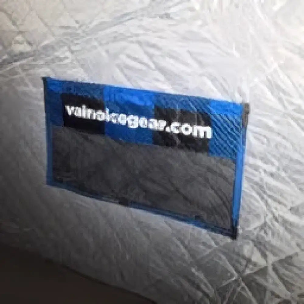 Sininen suorakaiteen muotoinen label väinö ice lodge 800 pilkkiteltan vaalealla kankaalla