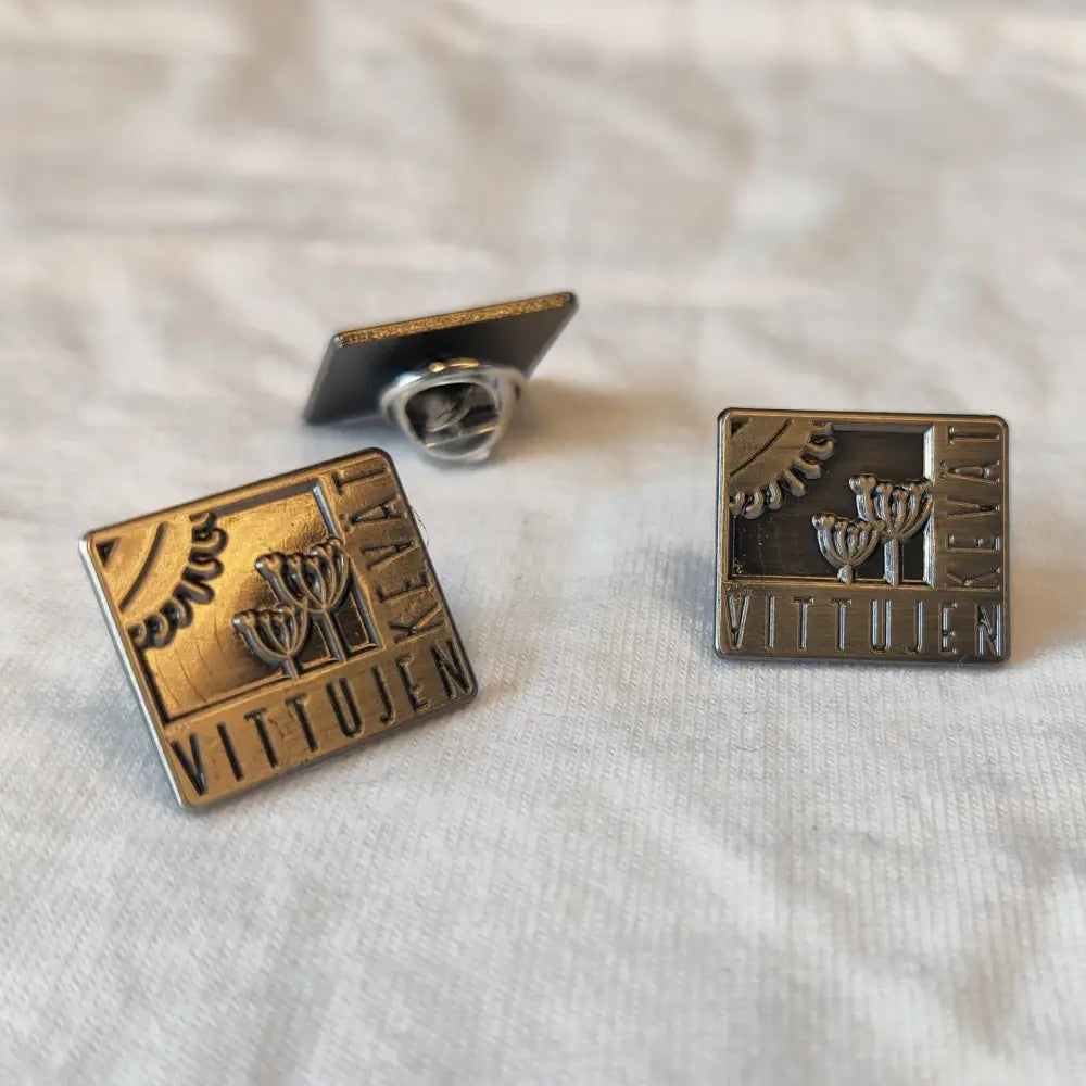 Suorakulmaiset metalliset vittujen kevät -logo pinsit, joissa on kaiverretut menorat ja kohokuvioitu vittujen teksti